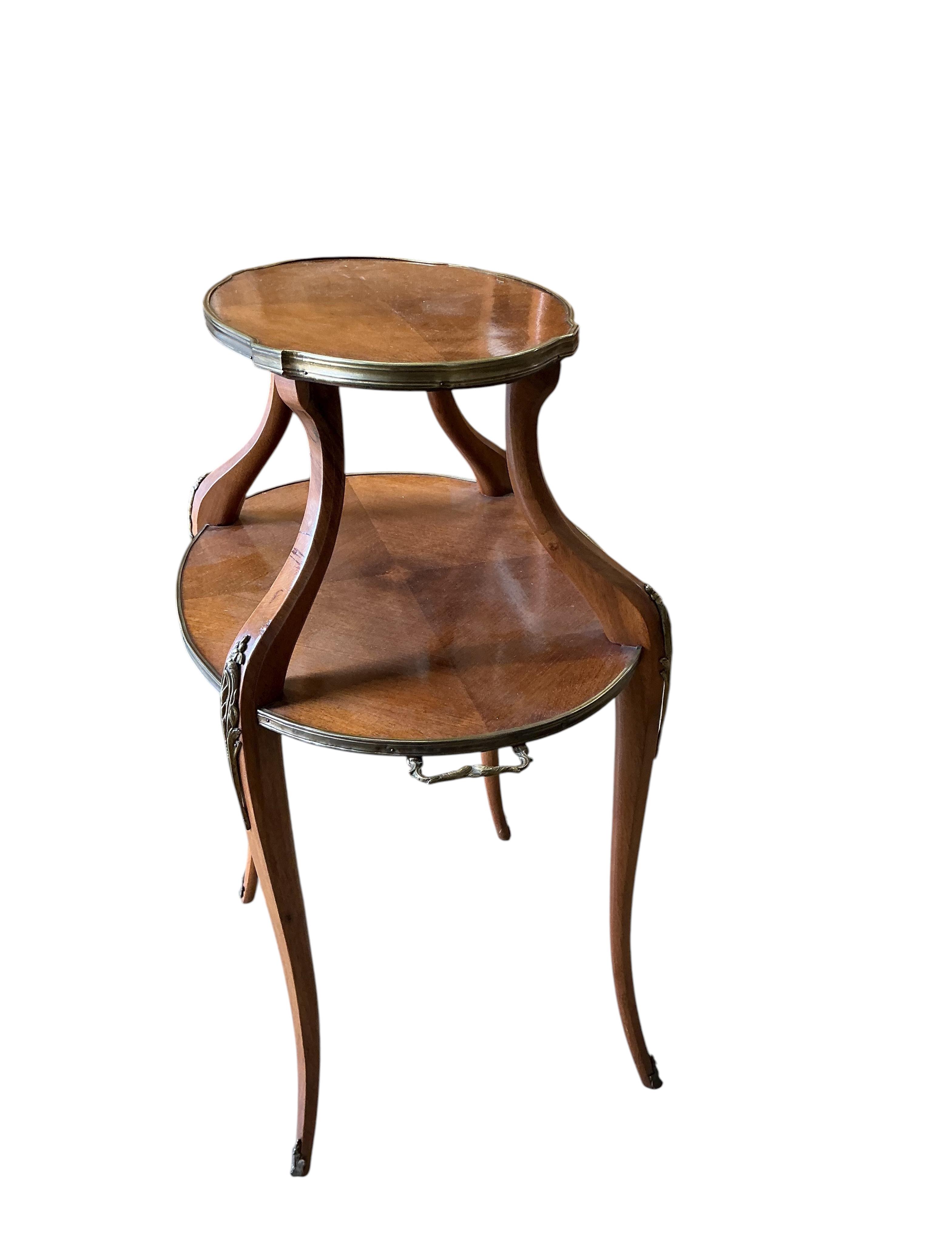 A gilt metal mounted oval mahogany two tier etagere, width 72cm, depth 46cm, height 88cm.